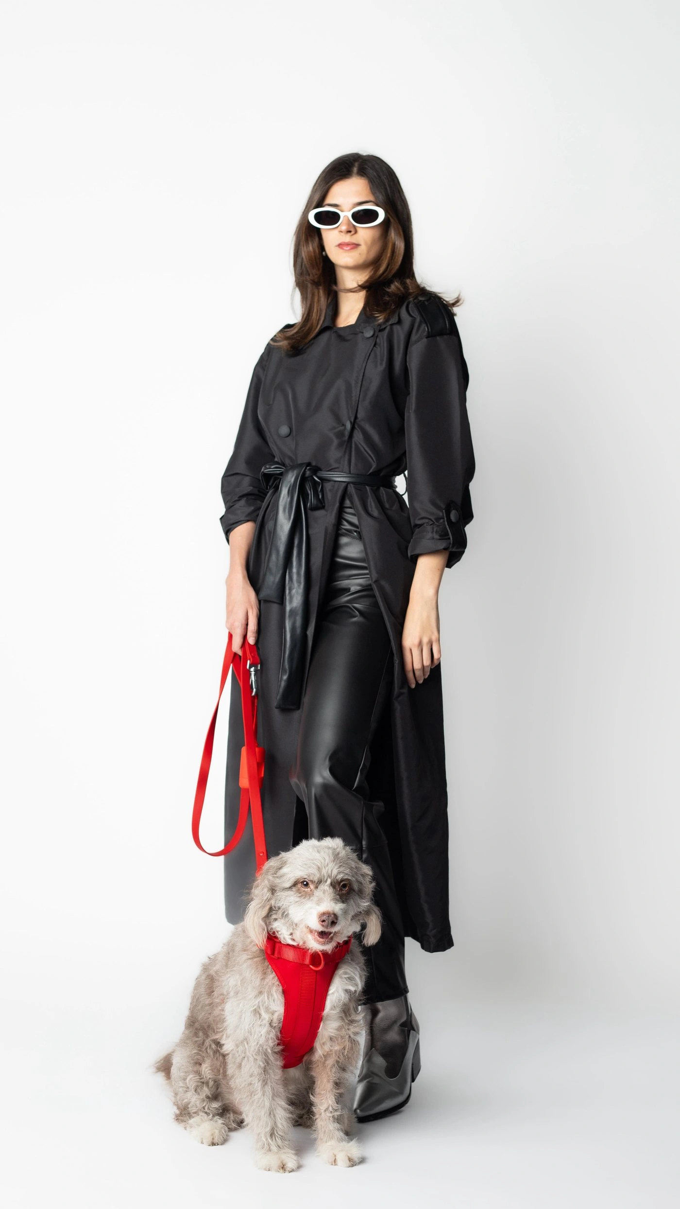 Modelo vestida de negro con un perro de pelo rizado