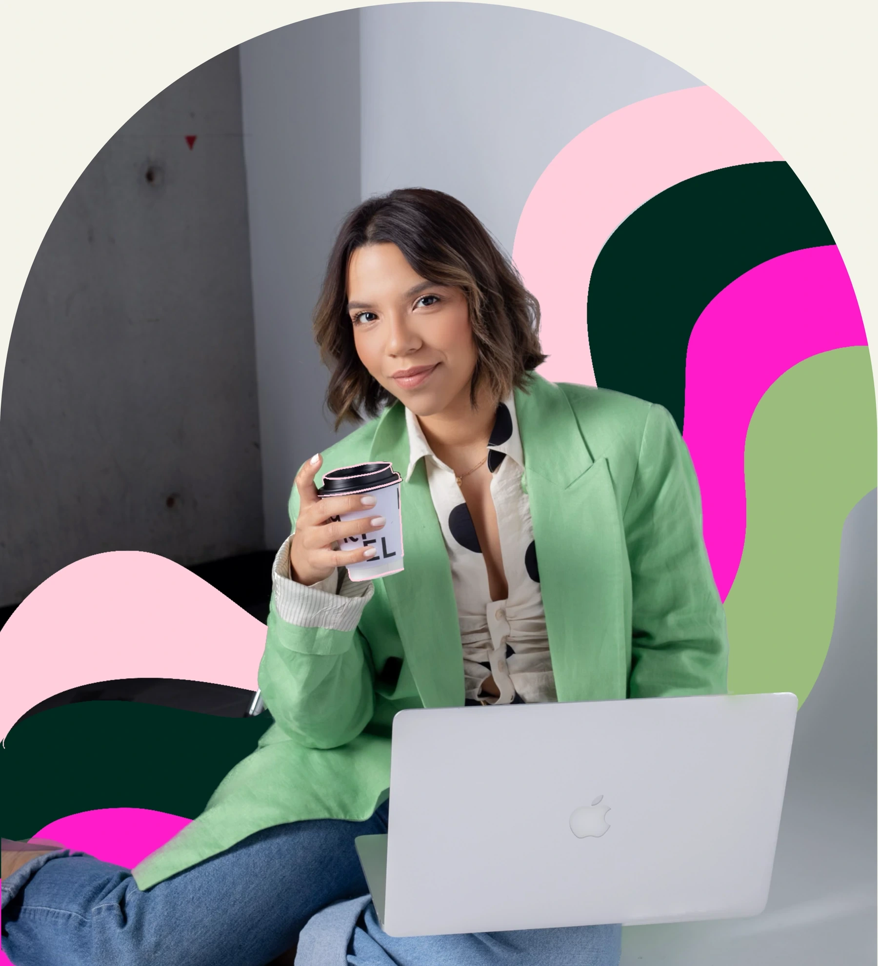 Madeline con blazer verde, café y laptop frente a formas de color