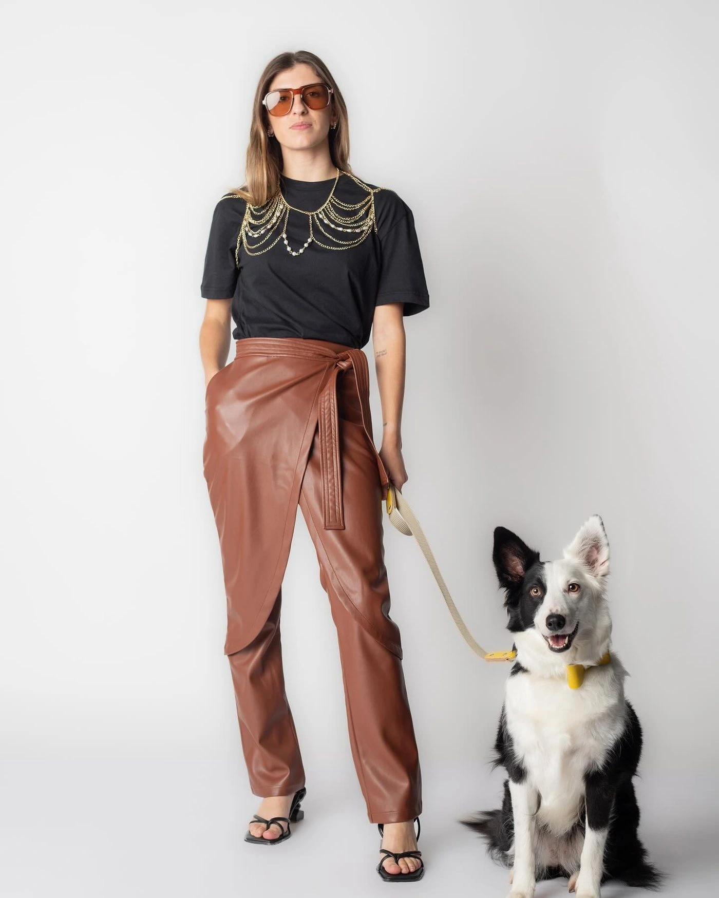 Modelo con pantalón de cuero y border collie