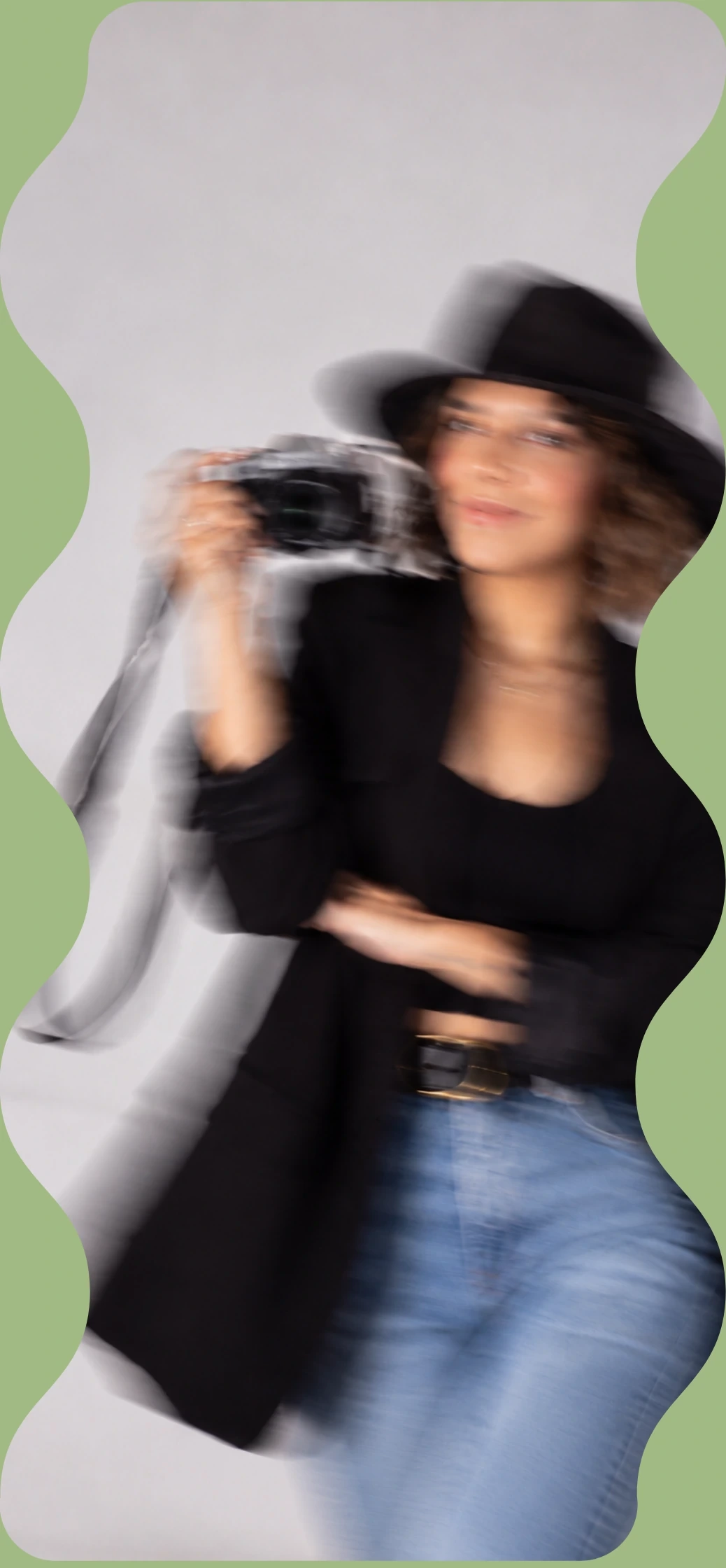 Fotógrafa en movimiento con cámara y sombrero negro